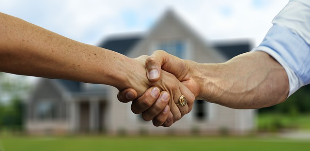 Image of a handshake in front of a home between tenant and realtor